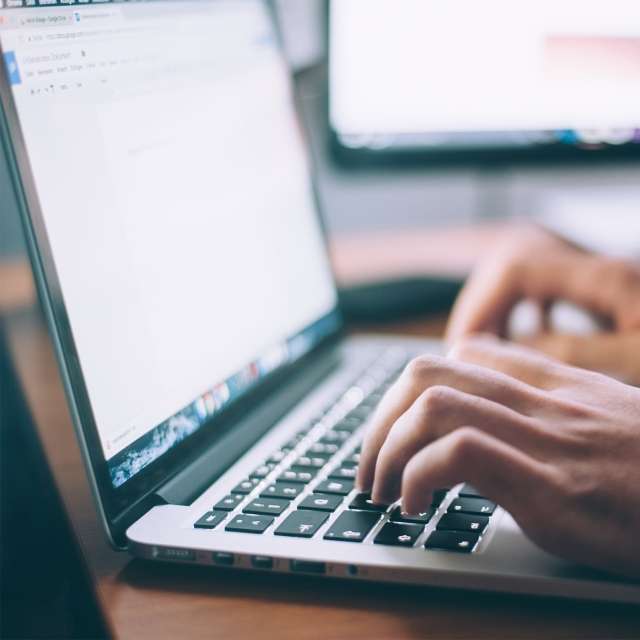 Closeup of person working on a word document on a laptop