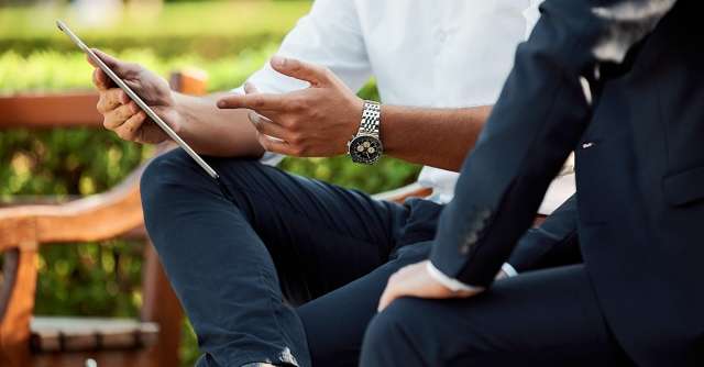 Two men reviewing content on a tablet