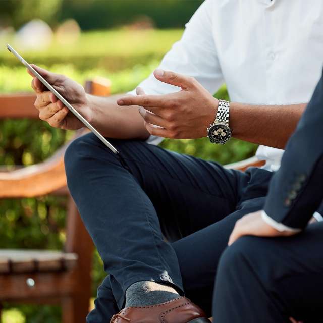 Two men reviewing content on a tablet