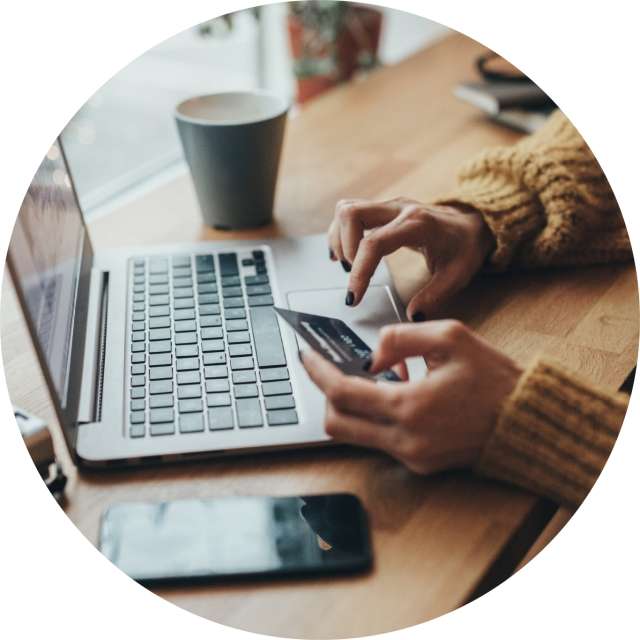 Woman using phone and typing on laptop 