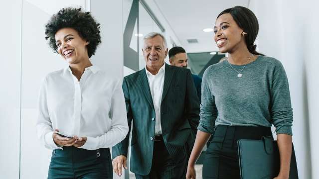 Coworkers smiling and walking in office