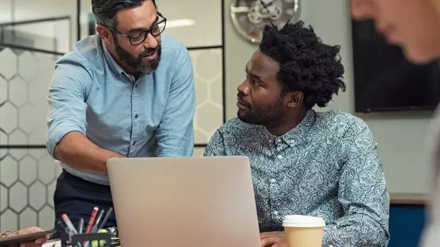 Two men looking at laptop