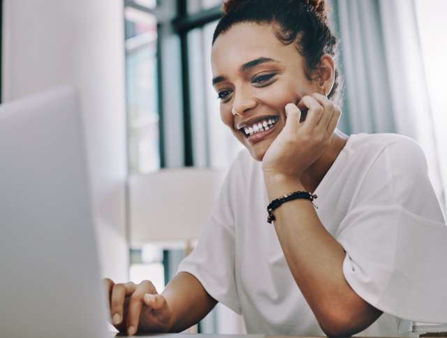 Woman smiling looking at laptop