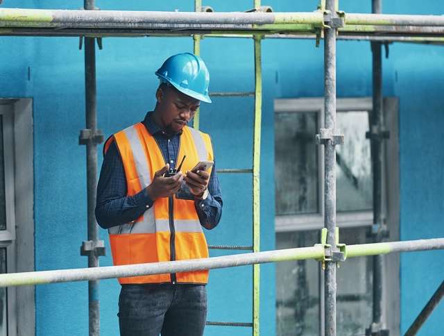 Construction worker using walkie talkie