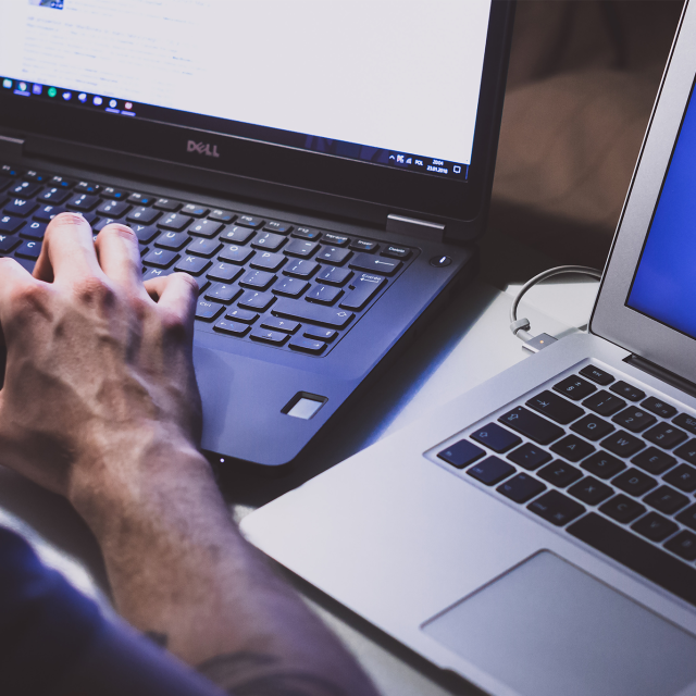 Man working on two laptops