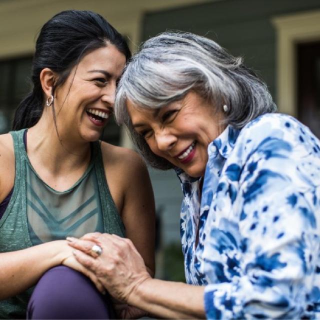 Two woman holding hands and laughing