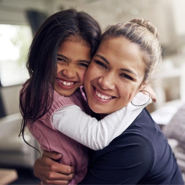 Mom hugging daughter and smiling