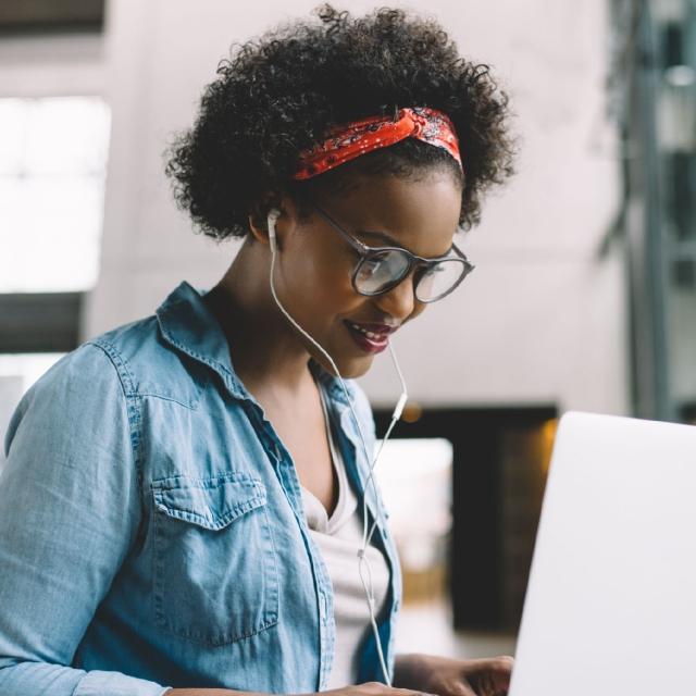 Woman working on laptop listening to music