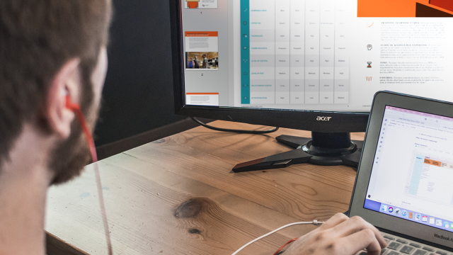 Man working on laptop and computer monitor